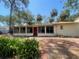 Back exterior view of home featuring a patio, tropical foliage and sunroom with large windows at 4711 W Vasconia St, Tampa, FL 33629