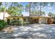 Charming single-story home featuring a brick facade, attached garage, and mature trees providing ample shade at 4711 W Vasconia St, Tampa, FL 33629