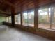 Bright sunroom with wood paneled ceiling and wall to wall windows offering views of the landscaped yard at 4711 W Vasconia St, Tampa, FL 33629