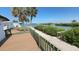 Breathtaking waterfront views from this wooden deck with green railing and lush tropical surroundings on a sunny day at 4851 W Gandy Blvd # 23C, Tampa, FL 33611