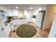 Well-lit kitchen featuring white cabinetry, modern appliances, granite countertops and a decorative rug at 4851 W Gandy Blvd # 23C, Tampa, FL 33611