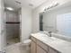 Well-lit bathroom featuring a marble vanity top and tiled shower with glass door at 5048 Sunridge Palms Dr # 103, Tampa, FL 33617