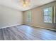 Bright bedroom with light wood-look flooring and two large windows at 5048 Sunridge Palms Dr # 103, Tampa, FL 33617