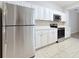 Well-lit kitchen showcasing stainless steel refrigerator, oven, microwave, and white cabinets at 5048 Sunridge Palms Dr # 103, Tampa, FL 33617