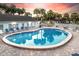 A bright and inviting community pool with lounge chairs sits next to a clubhouse under a colorful sky at 5048 Sunridge Palms Dr # 103, Tampa, FL 33617