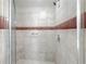 Tiled shower stall with glass door and horizontal accent tile at 5048 Sunridge Palms Dr # 103, Tampa, FL 33617