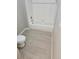 Cozy bathroom featuring tiled floors, toilet, and a bathtub with tiled surround at 5101 Corvette Dr, Tampa, FL 33624
