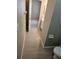 Hallway view to an en-suite bathroom with modern white cabinets and wood-look tile flooring at 5101 Corvette Dr, Tampa, FL 33624