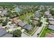 An aerial view of single-Gathering homes in a community with a serene pond, a golf course and manicured landscaping at 5340 Riva Ridge Dr, Wesley Chapel, FL 33544