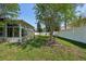 Wide shot of backyard featuring lush green grass and an enclosed sunroom attached to the house at 5340 Riva Ridge Dr, Wesley Chapel, FL 33544
