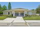 Exterior view of the clubhouse featuring a concrete sidewalk, columns, greenery, and bike racks at 5340 Riva Ridge Dr, Wesley Chapel, FL 33544