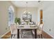 Bright dining room featuring a large arched window, chandelier, hardwood floors, and modern decor at 5340 Riva Ridge Dr, Wesley Chapel, FL 33544