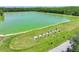 Golfers are using the Lexington Oaks Golf Club driving range near a lake and lush trees at 5340 Riva Ridge Dr, Wesley Chapel, FL 33544