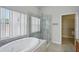 Soaking tub and glass shower in the bright, updated main bathroom at 5340 Riva Ridge Dr, Wesley Chapel, FL 33544