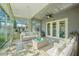 Virtually staged sunroom with tile floors, a ceiling fan, and wicker furniture, offering plenty of natural light at 5340 Riva Ridge Dr, Wesley Chapel, FL 33544