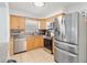 Well-equipped kitchen with stainless steel appliances, stone countertops, and warm wood cabinetry at 5542 19Th N Ave, St Petersburg, FL 33710