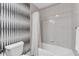 Clean bathroom with a shower-tub combo, unique accent wall, and practical design elements at 555 5Th Ne Ave # 1032, St Petersburg, FL 33701