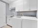 Well-equipped laundry room with white cabinets and appliances provides convenience and functionality at 555 5Th Ne Ave # 1032, St Petersburg, FL 33701