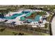 Aerial view of a resort-style community pool with lazy river, sun loungers, and tropical landscaping at 5717 Spivey Ct, Wesley Chapel, FL 33545