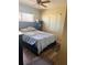 This bedroom features a window, wood-look flooring, ceiling fan, and natural light at 5805 Tennessee Ave, New Port Richey, FL 34652