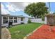 Backyard featuring green grass and mulch with a white fence, complemented by a small patio area with barbecue at 6149 37Th N Ave, St Petersburg, FL 33710