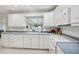 Bright kitchen with white cabinets and tile backsplash and stainless steel appliances under recessed lights at 6149 37Th N Ave, St Petersburg, FL 33710