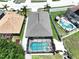 Aerial view of a home featuring a screened-in pool and spa, surrounded by a well-maintained yard and privacy fence at 6205 Chapel Pines Blvd, Wesley Chapel, FL 33545