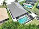 Impressive aerial view of screened pool and lanai, surrounded by lush greenery and a spacious backyard, perfect for outdoor living at 6205 Chapel Pines Blvd, Wesley Chapel, FL 33545