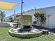 Relaxing backyard with built-in brick fireplace, outdoor kitchen, and sunny canopy, perfect for entertaining at 6205 Chapel Pines Blvd, Wesley Chapel, FL 33545