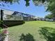 Expansive backyard with manicured lawn and spacious deck overlooking the enclosed pool area at 6205 Chapel Pines Blvd, Wesley Chapel, FL 33545