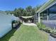 Green backyard with outdoor dining and cooking space that leads to a screened pool area at 6205 Chapel Pines Blvd, Wesley Chapel, FL 33545