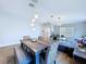 Open-concept dining area with a modern table, decorative chairs, and view into the living room at 6205 Chapel Pines Blvd, Wesley Chapel, FL 33545