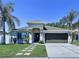 Inviting home exterior featuring manicured lawn, walkway pavers, and a two-car garage, creating a welcoming entrance at 6205 Chapel Pines Blvd, Wesley Chapel, FL 33545