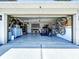 Open garage with epoxy flooring, home gym equipment, overhead storage, and bicycle racks at 6205 Chapel Pines Blvd, Wesley Chapel, FL 33545