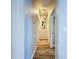 Bright hallway with wood-look floors and neutral walls, featuring artwork and modern lighting at 6205 Chapel Pines Blvd, Wesley Chapel, FL 33545