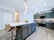 Well-lit kitchen island featuring seating, modern appliances and ample counter space at 6205 Chapel Pines Blvd, Wesley Chapel, FL 33545