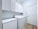 Functional laundry room with washer, dryer, freezer, and ample cabinet space for storage at 6205 Chapel Pines Blvd, Wesley Chapel, FL 33545