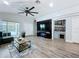 The stylish living room offers a ceiling fan, wood floors, a bar, and a view of the pool through sliding glass doors at 6205 Chapel Pines Blvd, Wesley Chapel, FL 33545