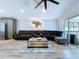 Spacious living room with gray L shaped couch, wood floors, and sliding glass doors leading to the patio at 6205 Chapel Pines Blvd, Wesley Chapel, FL 33545