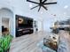 The stylish living room offers wood floors, a custom entertainment center with bar, and an open concept to the kitchen at 6205 Chapel Pines Blvd, Wesley Chapel, FL 33545