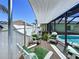Relaxing deck area with shaded awning, comfortable seating, and view of the screened pool at 6205 Chapel Pines Blvd, Wesley Chapel, FL 33545