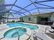 Inviting pool area featuring a heated spa, screened enclosure, and brick-paved deck perfect for outdoor relaxation at 6205 Chapel Pines Blvd, Wesley Chapel, FL 33545