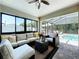 Cozy sunroom with comfortable seating, a ceiling fan, and views of the screened pool area at 6205 Chapel Pines Blvd, Wesley Chapel, FL 33545