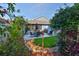 Lush backyard featuring a patio with seating, a well-maintained lawn, and tropical landscaping at 6232 Crickethollow Dr, Riverview, FL 33578