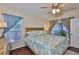 Bright bedroom with hardwood floors, ceiling fan, and a large window with views to the outside garden at 6232 Crickethollow Dr, Riverview, FL 33578