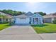 Charming single-story blue home featuring a two-car garage and well-maintained front lawn at 6232 Crickethollow Dr, Riverview, FL 33578
