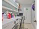 Functional laundry room featuring appliances, counterspace, storage cabinets, and neutral color palette at 6232 Crickethollow Dr, Riverview, FL 33578
