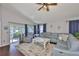 Comfortable living room with a ceiling fan, large sectional, and a view of the screened-in porch at 6232 Crickethollow Dr, Riverview, FL 33578