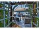 An outdoor patio view with a hot tub, seating and grill, framed by a pergola and lush tropical landscaping at 6232 Crickethollow Dr, Riverview, FL 33578