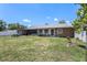 Wide shot of a spacious backyard with a well-maintained lawn and established trees at 702 Regent S Cir, Brandon, FL 33511